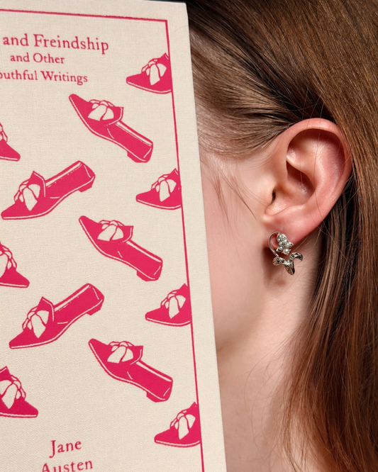 Model wearing Lily of the Valley pearl and 925 silver stud earrings beside a Jane Austen book, Regency-inspired jewellery