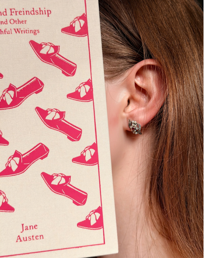 Model wearing Ruby Flower ruby and pearl 925 silver stud earrings beside a Jane Austen book, vintage-style studs