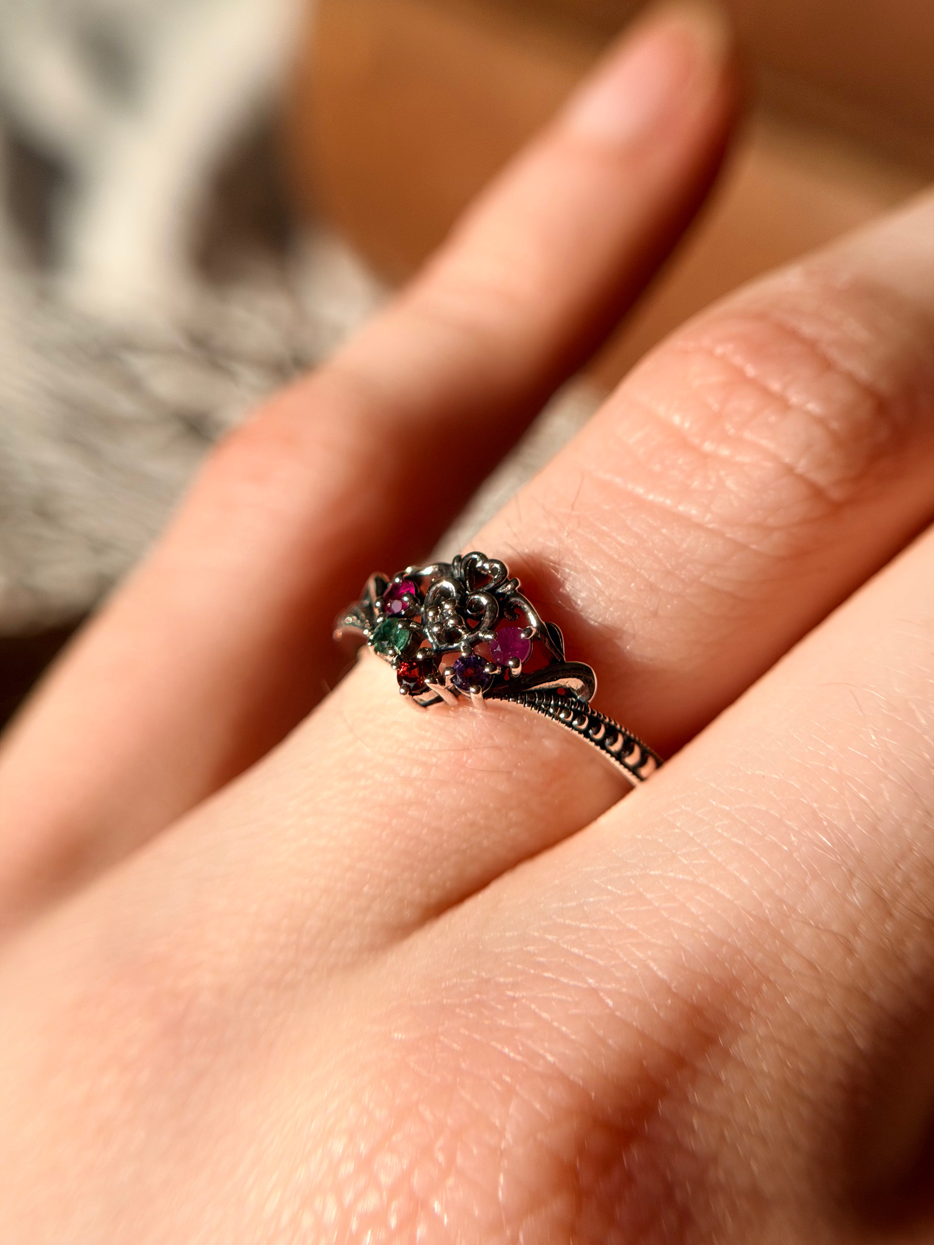 Hand wearing the Lover's Knot multi-gemstone 925 silver ring, antique-style Victorian love knot ring